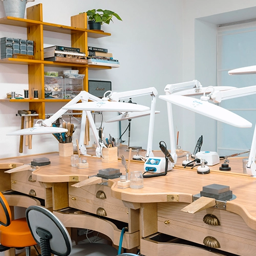 Servicio coworking con mesas de trabajo equipadas en taller de joyería profesional.